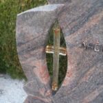 Detajl gravure na nagrobnem spomeniku z natančno obdelavo kamna.