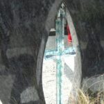 Stekleni križ vgrajen v granitni nagrobnik – detajl izdelave.