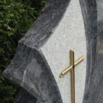 Bronasti križ v granitni plošči z ročno obdelavo.