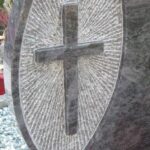 Detajl dvojnega granitnega nagrobnega spomenika s poudarkom na obdelavi.