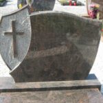 Dvojni klasični granitni nagrobni spomenik z urejeno okolico groba.