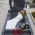 Nagrobni spomenik s steklenim križem ter vazo in cvetjem