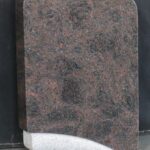 Detajl zaobljene zgornje oblike enojnega spomenika.