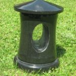 Črn graniten nagrobni svečnik na zelenici – nagrobni dodatek za lučko.