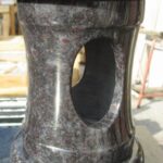 Graniten nagrobni svečnik z odprtino za lučko – klasičen nagrobni dodatek.